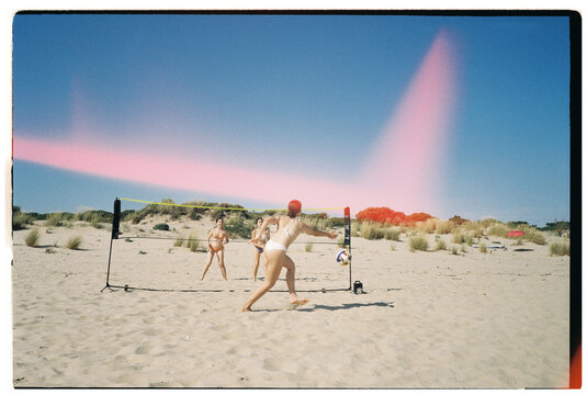 Teens playing beach volleyball
