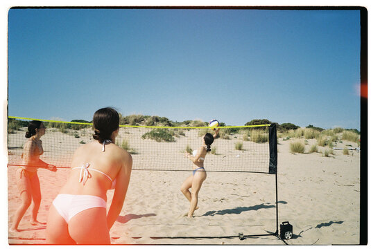 Teens playing beach volleyball
