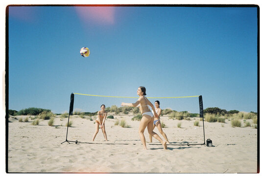Teens playing beach volleyball

