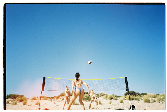 Teens playing beach volleyball
