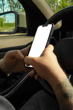 Male hands in a car holding a smartphone with an isolated white screen