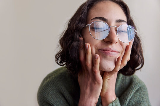Young woman wearing eyeglasses in natural light smiling