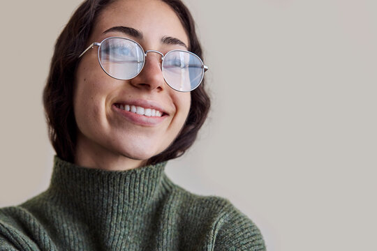 Young woman wearing eyeglasses in natural light smiling