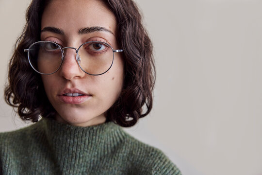 Young serious woman wearing eyeglasses in natural light