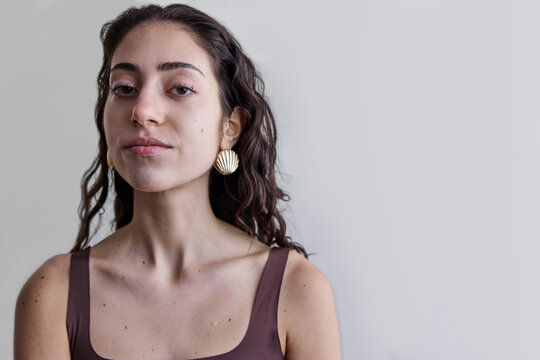 Young model with a seashell golden earring