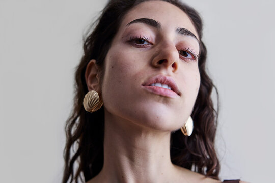 Young model with a seashell golden earring