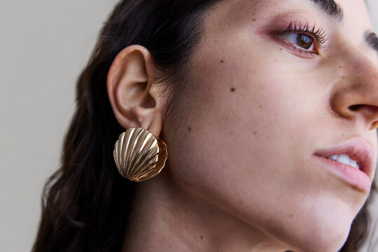 Young model with a seashell golden earring