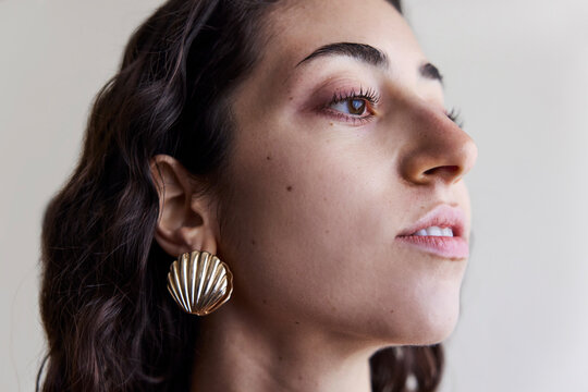 Young model with a seashell golden earring