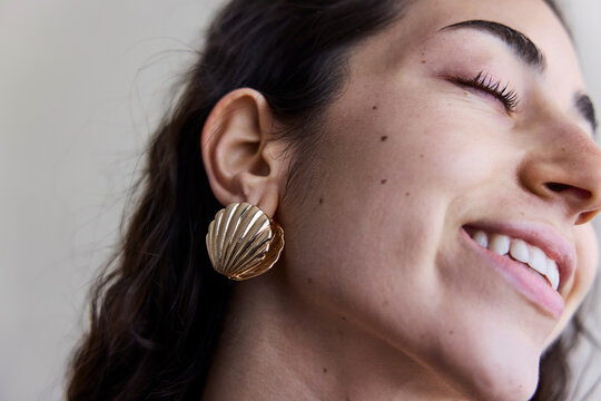Young model with a seashell golden earring