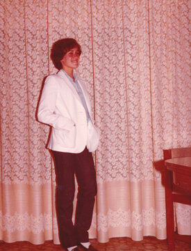 Woman in Stylish Attire by Patterned Curtains