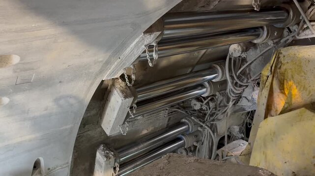 Railway tunnel excavation through mountainous terrain on line LK104 using TBM technology. Tunnel boring machine advancing underground with installation of precast concrete segments forming the tunnel.