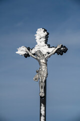 Iron cross with crucified Jesus covered in snow on top of Nova Hola in Donovaly Slovakia © Stefan