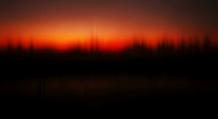 Obraz premium Vibrant orange sunset over a silhouette landscape