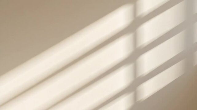Soft diagonal shadow stripes cast across a neutral textured wall by natural light