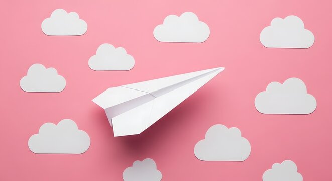 White paper airplane flying against a pink sky with white clouds