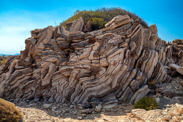 Folded sedimentary rock formations near Agios Pavlos in southern Crete Greece under blue sky