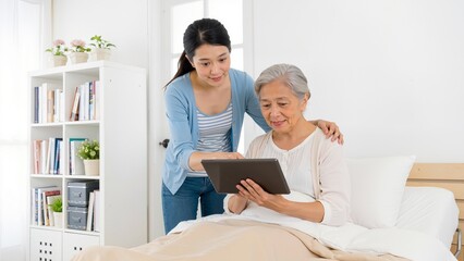 Obraz premium Young woman assisting elderly person with tablet
