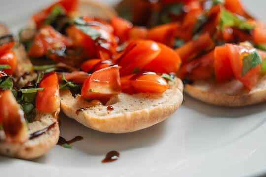 Fresh bruschetta with tomatoes and basil drizzled with balsamic vinegar