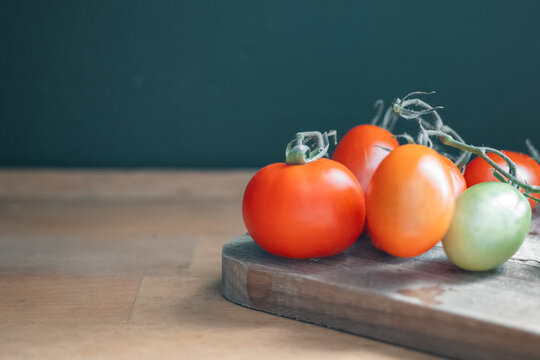 Fresh ripe tomatoes on wooden board with copy space
