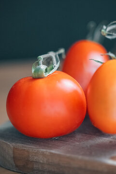Plump red ripe tomatoes on wooden board