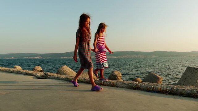 Two little beautiful girls walk in Nesebar, Bulgaria