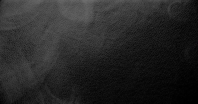 Dark leather texture with a smooth haze. A high-resolution dark leather texture background captured in smooth, rotational motion.