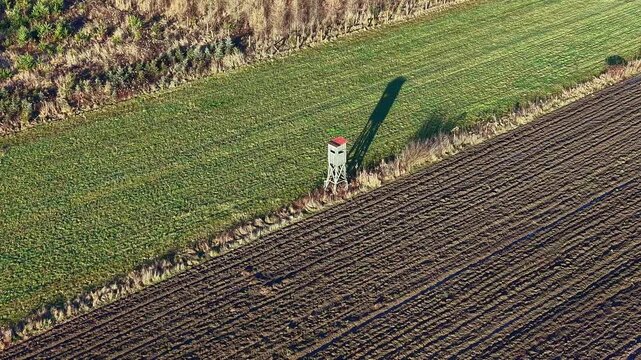 Wildlife observation tower in wide green field