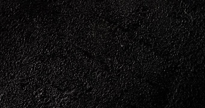 Black grunge background seamless loop.. A high-resolution dark texture background captured in smooth motion.