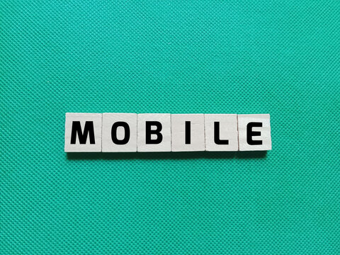 Alphabet letters of the word MOBILE on a green background. Concept photo about mobile technology, applications, or systems that can be used anywhere without having to be in one fixed place.
