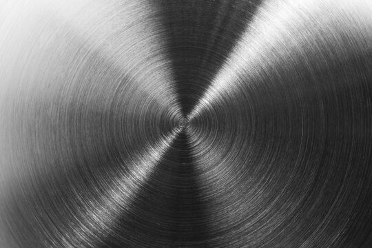Brushed stainless steel metal texture background with circular polished pattern and shiny silver reflection.