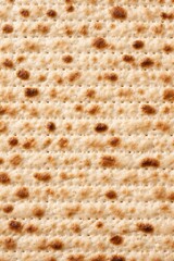Detailed view of matzo bread displaying its characteristic texture and color, emphasizing the baked spots and surface irregularities