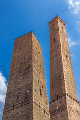 The iconic Asinelli Tower and neighboring Garisenda Tower in Bologna, Italy, known for their impressive medieval architecture and rich history under a clear blue sky.