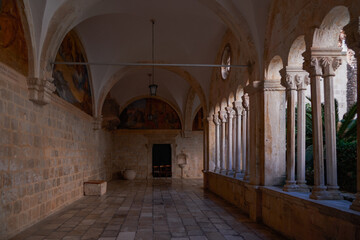 Fototapeta premium Romanesque cloister with double columns and frescoes at Franciscan Monastery - Dubrovnik, Croatia