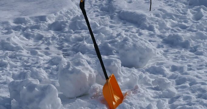 yellow snow shovel lying on the snow