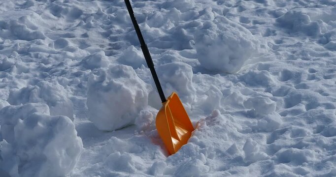 yellow snow shovel lying on the snow