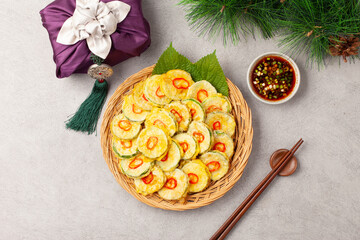 호박전 얇게 썬 애호박에 소금을 조금 뿌려서 두었다가 밀가루를 묻히고 달걀 푼 것을 씌워 부친 전

Pumpkin pancakes: Thinly sliced ​​zucchini sprinkled with a little salt, then coated in flour, covered in beaten egg, and fried.
