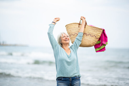 Excited senior woman celebrating at the beach