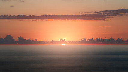 Bright beautiful orange sunset on the beach and by the sea, smooth sea, sunny path in the sea, sun...