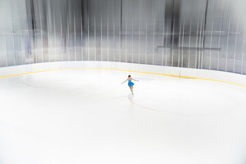 Elegant Figure Skater Performing Graceful Spin on Ice Rink