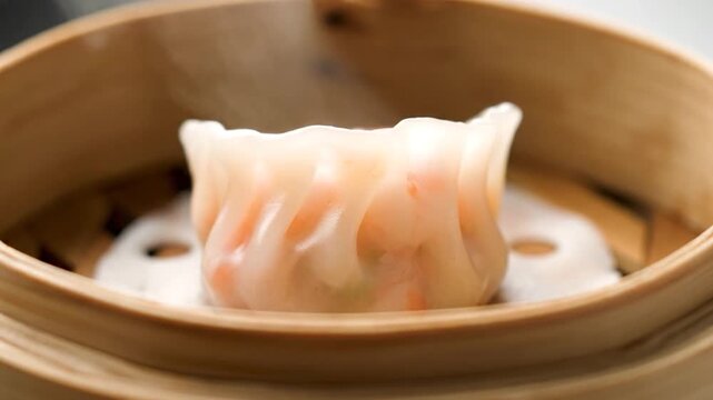 Closeup of a Steaming Har Gow Dumpling in a Bamboo Steamer Basket.