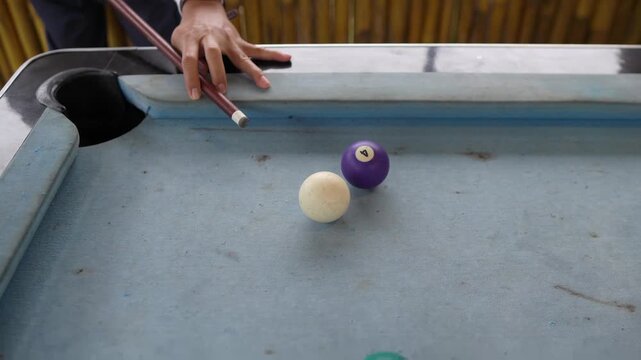Billiards game action, striking the cue ball to sink a shot in the pocket