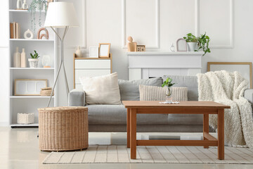 Fototapeta premium Interior of light living room with sofa, table and shelf unit