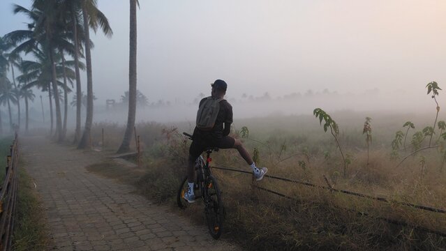 man on bicycle in winter jungle