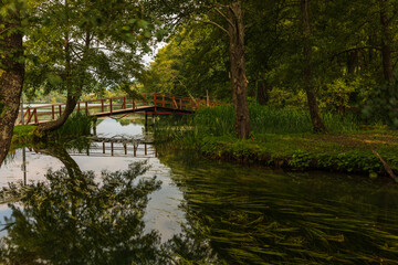 Obraz premium Wooden bridge crossing tranquil water in Jajce, Bosnia and Herzegovina.
