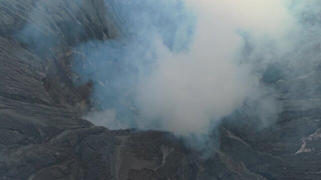 Aerial view of mount bromo volcano crater emitting smoke