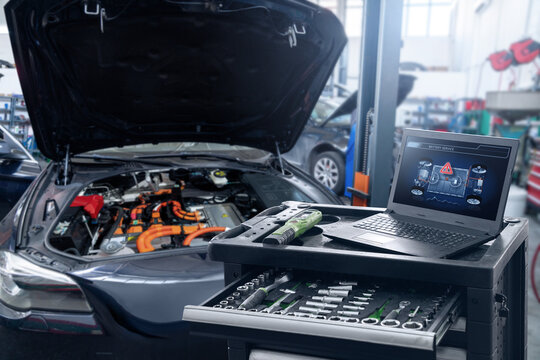 Checking the battery pack of an electric car at a service center.