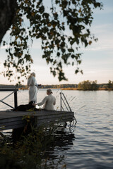 Obraz premium Two women with Bernese mountain dog on lakeside dock 