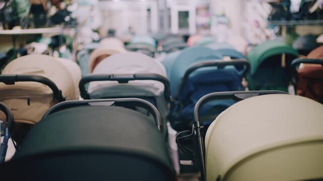 Rear view of multiple baby strollers arranged in rows inside a store