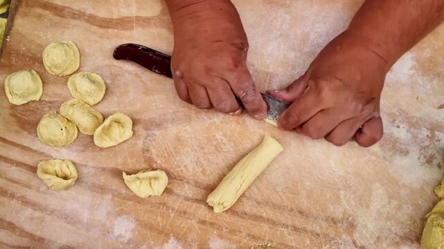 Detailed shot of hands making fresh Orecchiette pasta in Bari, Italy