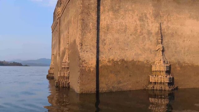 traveling sailing on river lake pond to see old temple sank in water